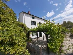 a white house with bushes in front of it at Country house Viskic in Supetarska Draga