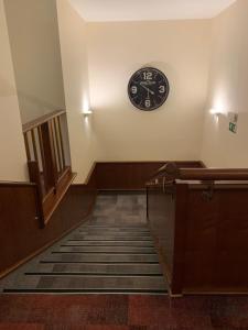 une horloge sur un mur au-dessus d'un escalier avec une horloge dans l'établissement Hotel Mantova, à Vrhnika