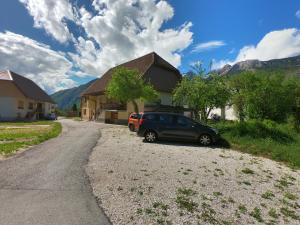 a car parked on the side of a road next to a house at Holiday Home Over The River in Bovec
