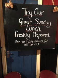 Znak z napisem "Spróbuj naszego wspaniałego niedzielnego lunchu świeżo przygotowanego" w obiekcie The Old Tea House w mieście Dorchester
