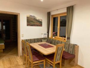 een eetkamer met een houten tafel en stoelen bij Brandnerhof in Bad Hofgastein