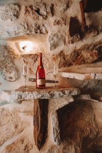 a bottle of wine and two glasses on a stone wall at The old stable 1861 in Imotski