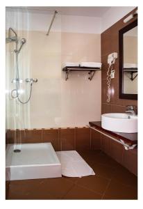 a bathroom with a shower and a sink and a tub at AselTur Brasov in Braşov