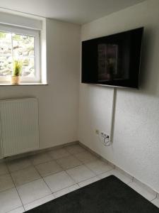a room with a tv on the wall and a window at Ferienwohnung "Vier Pfoten" in Korbach in Korbach +11 photos