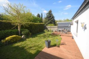 a backyard with a wooden deck with a table and a tree at Ferienhaus Abendsonne in Lübeck