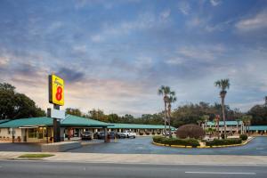 un restaurante de comida rápida con un cartel en un estacionamiento en Super 8 by Wyndham Pensacola NAS Area en Pensacola