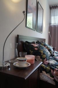 une table avec une tasse de café, une lampe et un canapé dans l'établissement Apartament Gliwice Centrum Dunikowskiego z garażem, à Gliwice