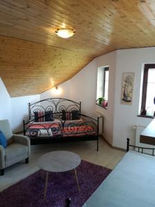 a bedroom with a bed and a couch and a table at Vila Štefan Drevko in Poprad