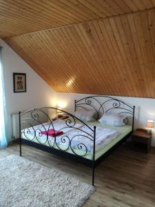 a bedroom with a metal bed with a wooden ceiling at Vila Štefan Drevko in Poprad