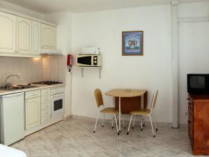 a kitchen with a table and chairs and a microwave at Apartamentos King's in Quarteira