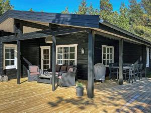 a pavilion with a table and chairs on a deck at Three-Bedroom Holiday home in Rømø 9 in Bolilmark
