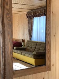 a mirror reflection of a couch in a bedroom at Апартаменты Solnce Karpat in Polyana