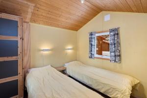 two beds in a small room with a window at Birkelund camping in Geilo