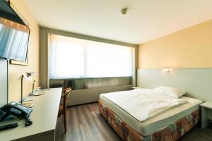 A bed or beds in a room at City Hotel Heilbronn