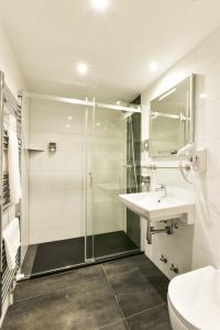a bathroom with a shower and a sink and a toilet at City Hotel Heilbronn in Heilbronn
