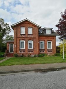 a red brick house on the side of a street at Richters Deich-Oase in Brokdorf