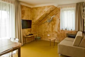 uma sala de estar com um sofá e uma televisão em Apartmány Modřínová Archa s privátní saunou em Vaclavov u Bruntalu