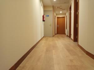 an empty hallway in an office building with a hard wood floor at Pensión Begoña - centro ciudad in Bilbao