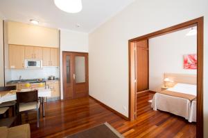 a small apartment with a kitchen and a bedroom at Hotel Apartamentos Dabarca in Pontevedra