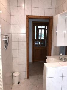 a bathroom with a sink and a toilet and a door at Dat Sottje Huus in Wilhelmshaven