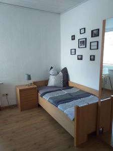 een slaapkamer met een bed met een houten frame en een raam bij Dat Sottje Huus in Wilhelmshaven