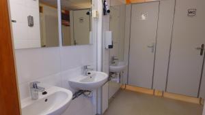 a bathroom with two sinks and two mirrors at Birkelund camping in Geilo +19 photos