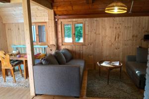 a living room with a couch and a table at Malebná chata v lese in Opátka