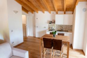 a kitchen and dining room with a wooden table and chairs at B&B Sopralapanca in Postalesio