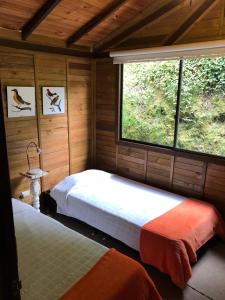 A bed or beds in a room at Cabañas Valle del Cocora La Truchera