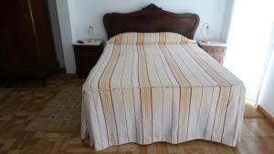 a bed with a striped blanket on top of it at Casa de Férias in Monchique