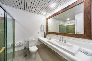 La salle de bains est pourvue d'un lavabo, de toilettes et d'un miroir. dans l'établissement Arraial D'ajuda Eco Resort, à Arraial d'Ajuda