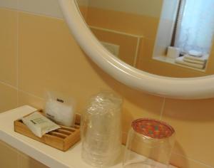 a bathroom counter with a tray of soap and a mirror at Agritur Bortolotti in Pergine Valsugana
