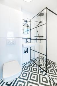 een badkamer met een zwart-witte vloer en een witte stoel bij Apartament Oławska in Wrocław