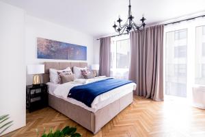 a bedroom with a large bed and a chandelier at Apartament Oławska in Wrocław