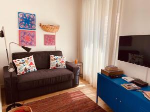 a living room with a couch and a tv at Enjoy Casa do Forte Apartment in Lisbon