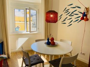 uma sala de jantar com uma mesa branca e cadeiras em Enjoy Casa do Forte Apartment em Lisboa