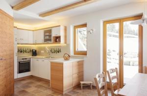 cocina con armarios blancos y mesa en Apartment Jezerca - Krvavec en Cerklje na Gorenjskem