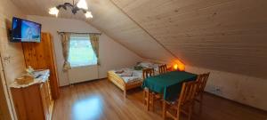 a dining room with a green table in a attic at Rafi House Relax i Spa dom koło Szczyrku in Szczyrk