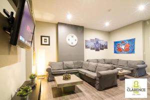 uma sala de estar com um sofá e uma televisão de ecrã plano em The Clarence Park em Toronto