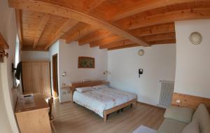 1 dormitorio con cama y techo de madera en Agritur Bortolotti, en Pergine Valsugana