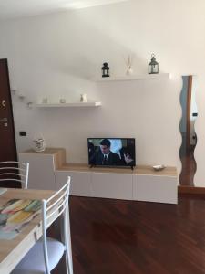 a living room with a tv on a white wall at Dali House Airport And Fiera in Fiumicino