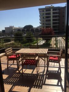 een houten tafel en stoelen op een balkon bij Dali House Airport And Fiera in Fiumicino