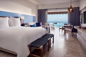 um quarto com uma cama grande e uma sala de estar em Four Seasons Resort Punta Mita em Punta Mita