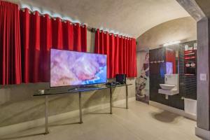 a room with red curtains and a flat screen tv at Spa urbano Motel Adult Only in Fortaleza