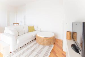 un soggiorno bianco con divano bianco e TV di Sirena Apartment a Riccione