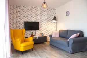 ein Wohnzimmer mit einem Sofa und einem Stuhl in der Unterkunft Apartamenty JustRent Szczyrk in Szczyrk
