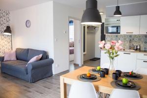 a kitchen and living room with a table and a couch at Apartamenty JustRent Szczyrk in Szczyrk