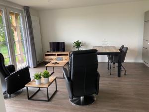 uma sala de estar com mesa e cadeiras e uma sala de jantar em Hof van Lenthe appartement De Mars em Dalfsen