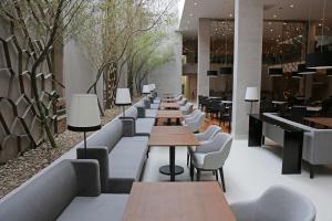 a row of tables and chairs in a restaurant at NH Collection Curitiba in Curitiba
