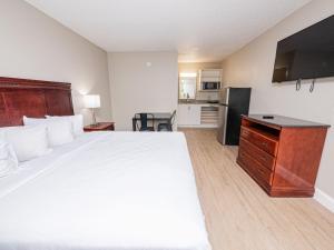レイクランドにあるStayable Lakelandの大きなベッドとキッチンが備わるホテルルームです。